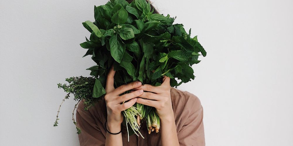 woman holding green Vegetables